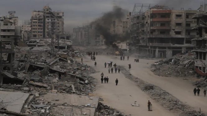 68f5973cbfaee-warga-gaza-berjalan-di-tengah-puing-reruntuhan-bangunan-saat-gencatan-senjata_665_374.jpeg
