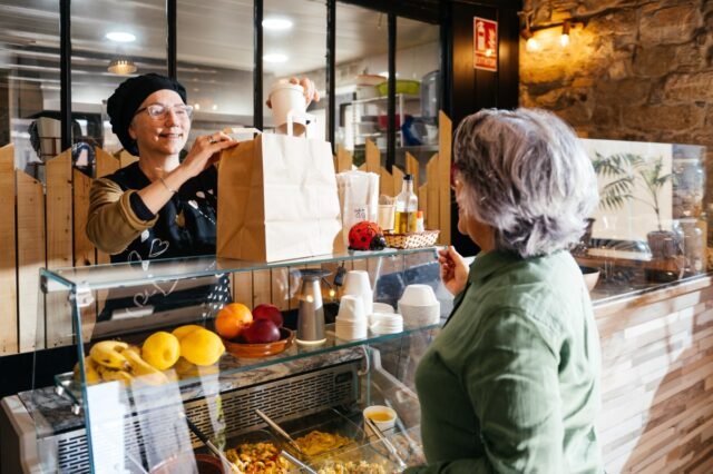 delighted-woman-serves-takeaway-food-to-a-customer-2025-01-09-12-37-00-utc_418600.jpg
