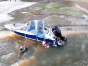 Un momento conmovedor cuando cuatro hombres se aferran a un barco atrapado en el borde de una presa de 130 pies