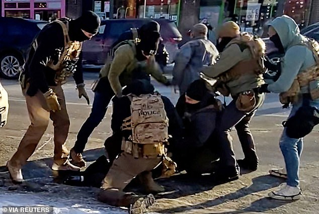105843839-15499659-The_moment_multiple_federal_agents_apprehended_Alex_Pretti_disar-a-15_17694600061.jpeg
