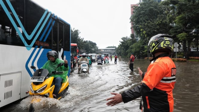 6972ad8ec1483-petugas-dishub-mengatur-arus-lalu-lintas-di-tengah-banjir-di-panjaitan-jaktim_665_374.jpeg