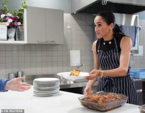 ¡Brillante duquesa! Meghan luce aretes de corazón de $1,100, el reloj Cartier de Diana y una pulsera de oro Tiffany mientras sirve el almuerzo a mujeres sin hogar en un refugio de Melbourne.