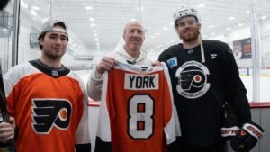 Un fanático de los Philadelphia Flyers desvía el palo de Cam York del gol de campo ganador